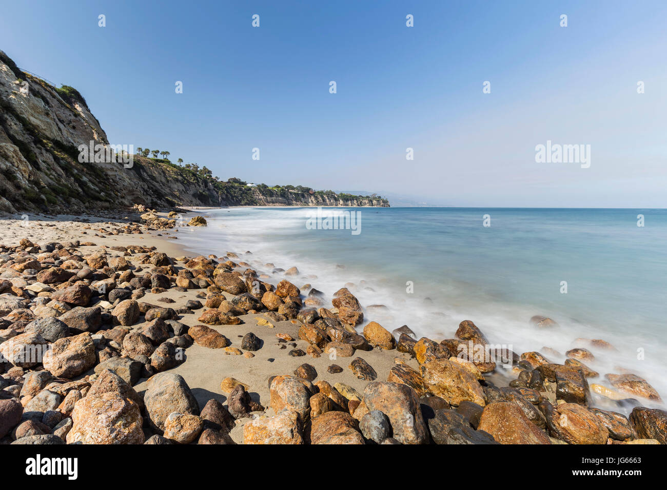 Spiaggia rocciosa con motion blur le onde a appartato Dume Cove in Malibu, California. Foto Stock