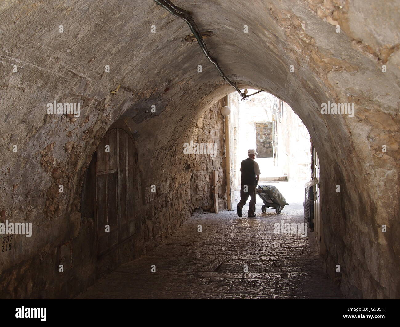 Gerusalemme, Israele - 02 Giugno, 2017: un uomo spinge un carrello della spesa attraverso un tunnel in Gerusalemme atmosferica. Foto Stock