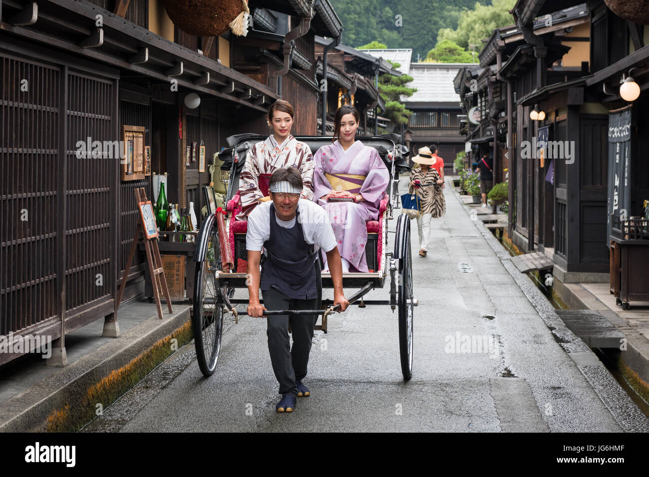 Geisha in abbigliamento tradizionale utilizzando tradizionale giapponese del trasporto pubblico, la potenza umana risciò. Takayama e Giappone. Foto Stock