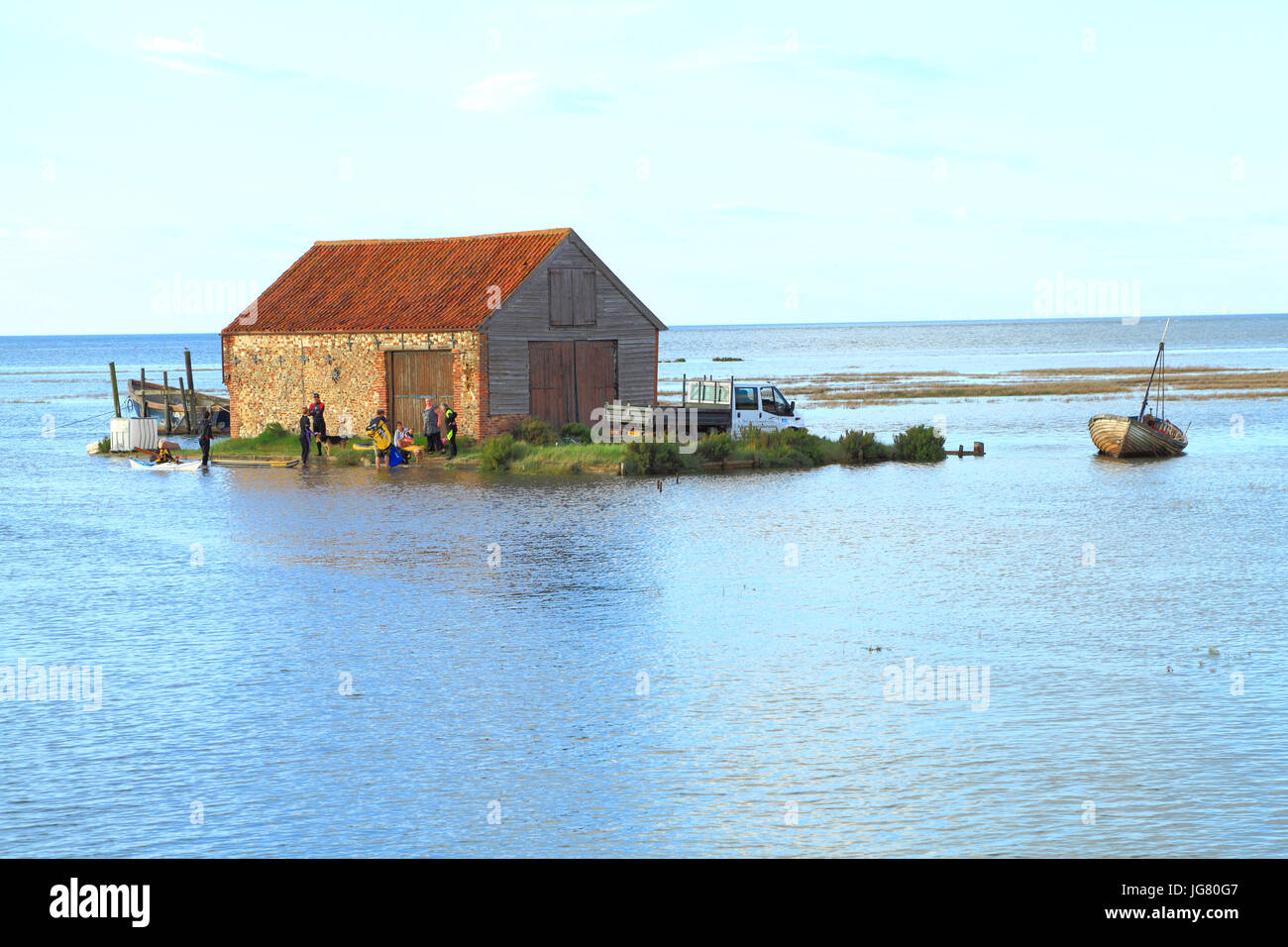 Tagliare da alta marea, van, carrello, persone Mare del Nord di corrente di picco del carbone nel fienile, Thornham, Norfolk, Inghilterra, Regno Unito. delle maree, delle maree, costa, coste, fregata, gonfi Foto Stock