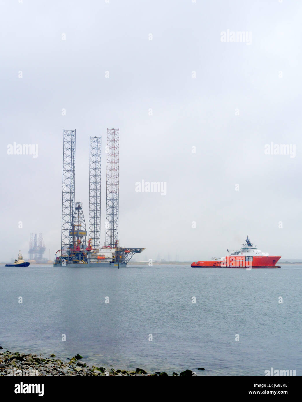 Rotte Teesport redcar cleveland, Regno Unito. 4 Luglio, 2017. Oggi il giacimento petrolifero Jack up trivellatrice Escom 102 è stato trainato da un cantiere di riparazione sul Fiume Tees dopo il completamento dei lavori di manutenzione in piovoso misty meteo. Porto rimorchiatori assistita in manovra del rig fuori nel canale di spedizione e andando Oceano Pacifico rimorchiatore Duchessa ha iniziato il rimorchio per il Firth of Forth. Credito: Pietro Giordano NE/Alamy Live News Foto Stock