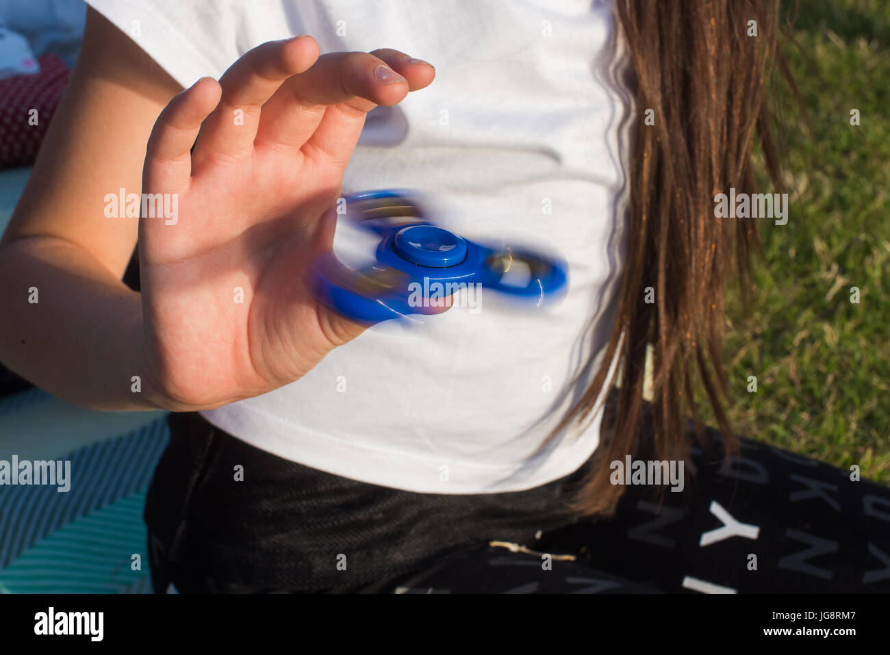 Una ragazza adolescente detiene filatrici. Giocattoli moderni. La moda di intrattenimento. Anti-stress. Foto Stock