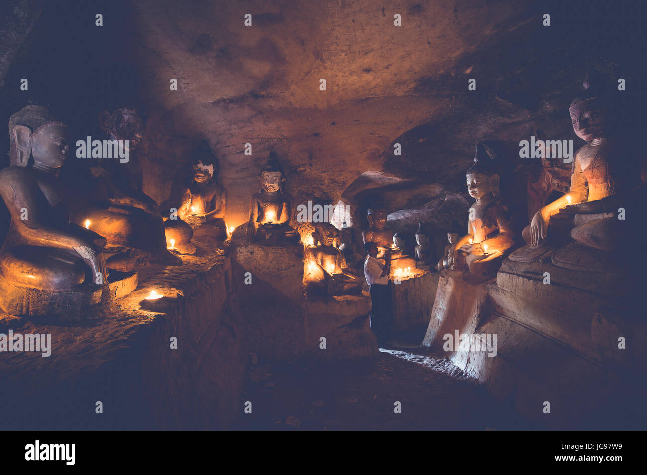 Preghiera birmano pregando all'interno della grotta di statue di Buddha nel Po Win Daung Monywa grotte Sagaing regione Nord del Myanmar Foto Stock