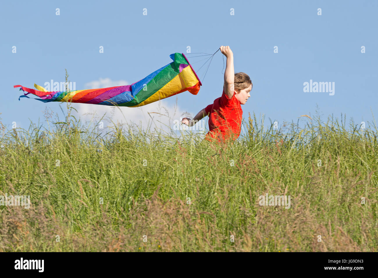 Giovane ragazzo in esecuzione con il manicotto del vento, Bleckede, Bassa Sassonia, Germania Foto Stock