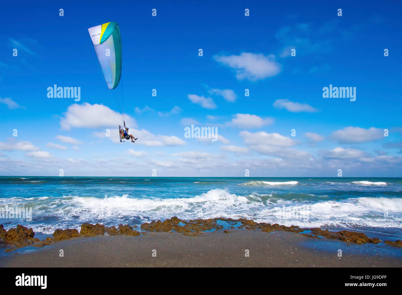 Un parapendio motorizzato le vele oltre le onde dell'Oceano Atlantico su una spiaggia della Florida. Foto Stock