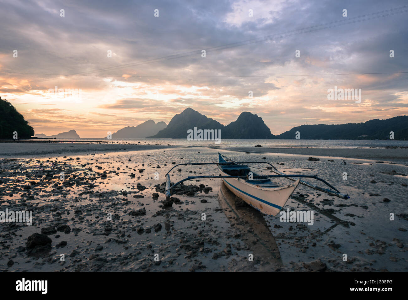 EL NIDO, PALAWAN FILIPPINE - MARZO 29, 2017: un ampio angolo di visione del tramonto con un singolo battello a Las Cabanas Beach. Foto Stock