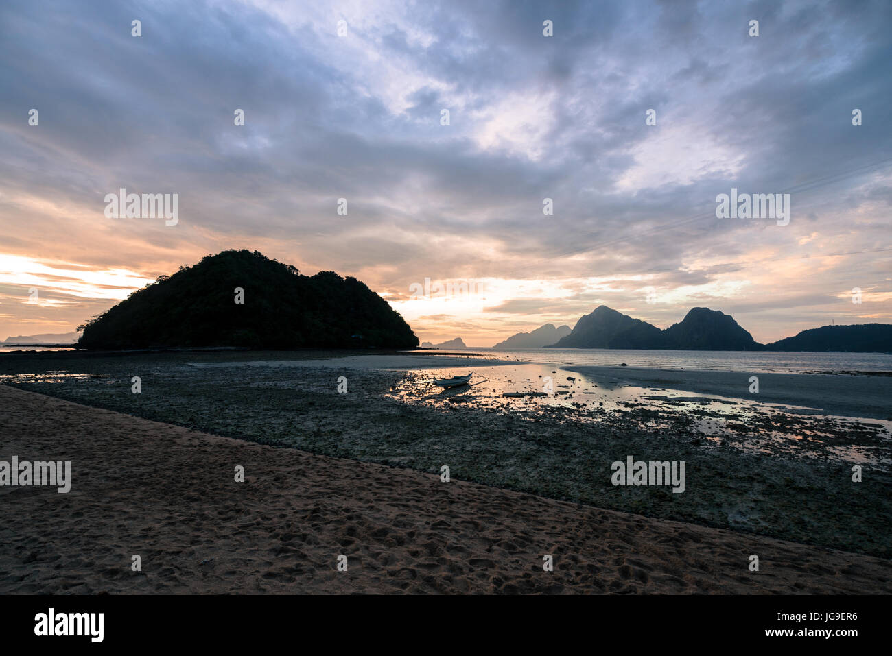 EL NIDO, PALAWAN FILIPPINE - MARZO 29, 2017: un ampio angolo di visione del tramonto con un singolo battello a Las Cabanas Beach. Foto Stock