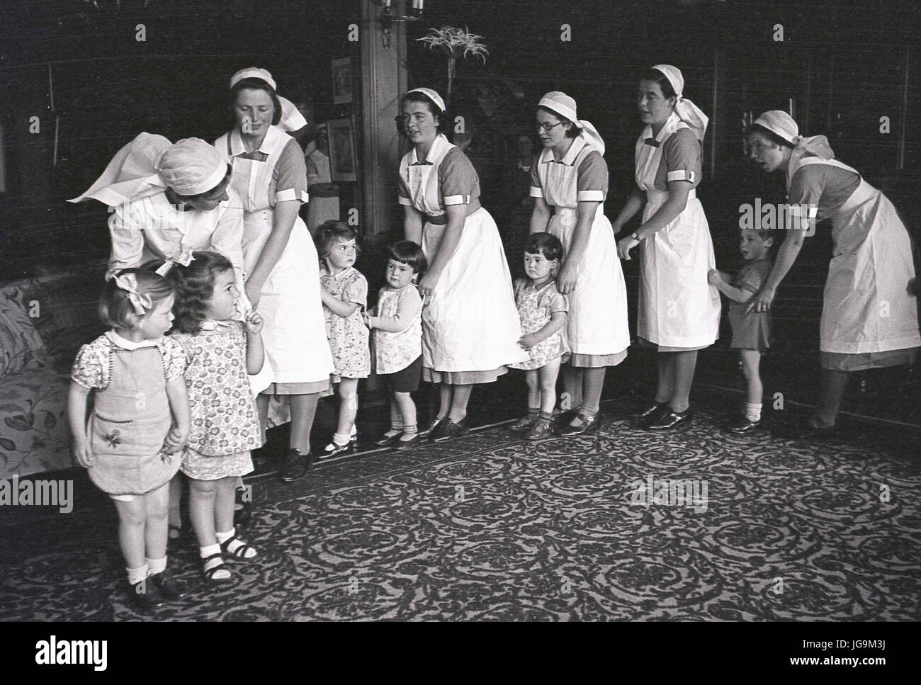 1940, in Inghilterra, in tempo di guerra, Stanstead Hall Country home di Lady Butler (Sydney Courtauld) moglie del maggiordomo di Rab, politico conservatore, immagine mostra personale domestico all'interno allineando con i bambini sfollati da Londra. Foto Stock