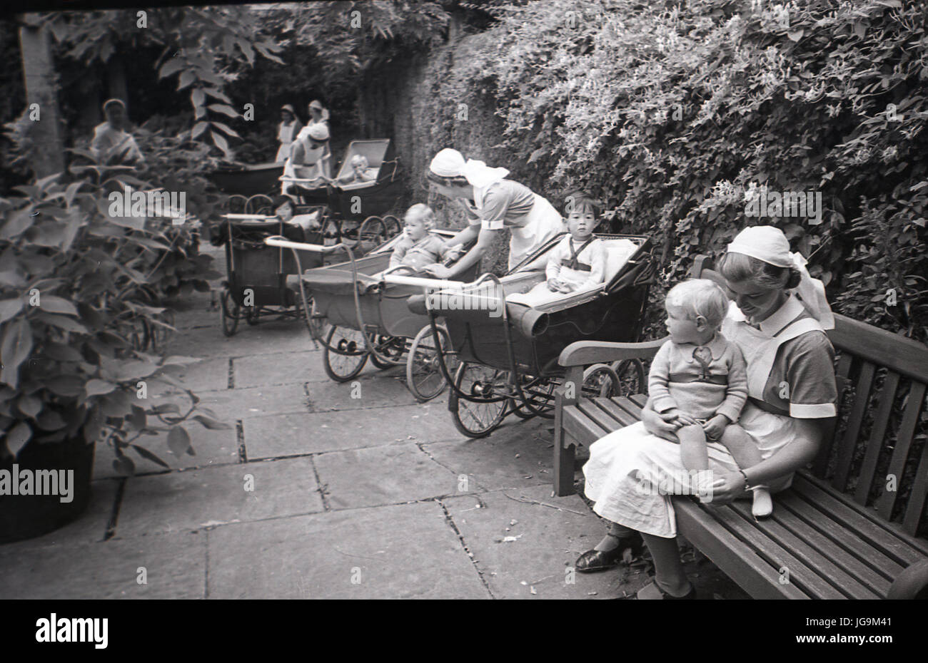 1940, in Inghilterra, in tempo di guerra, recentemente evacuateed bambini piccoli in carrozzina sono curati da infermieri o bambinaie a Stanstead Hall, Essex, casa di lady Butler (Sydney Courtauld) moglie del partito conservatore politican maggiordomo di Rab. Foto Stock