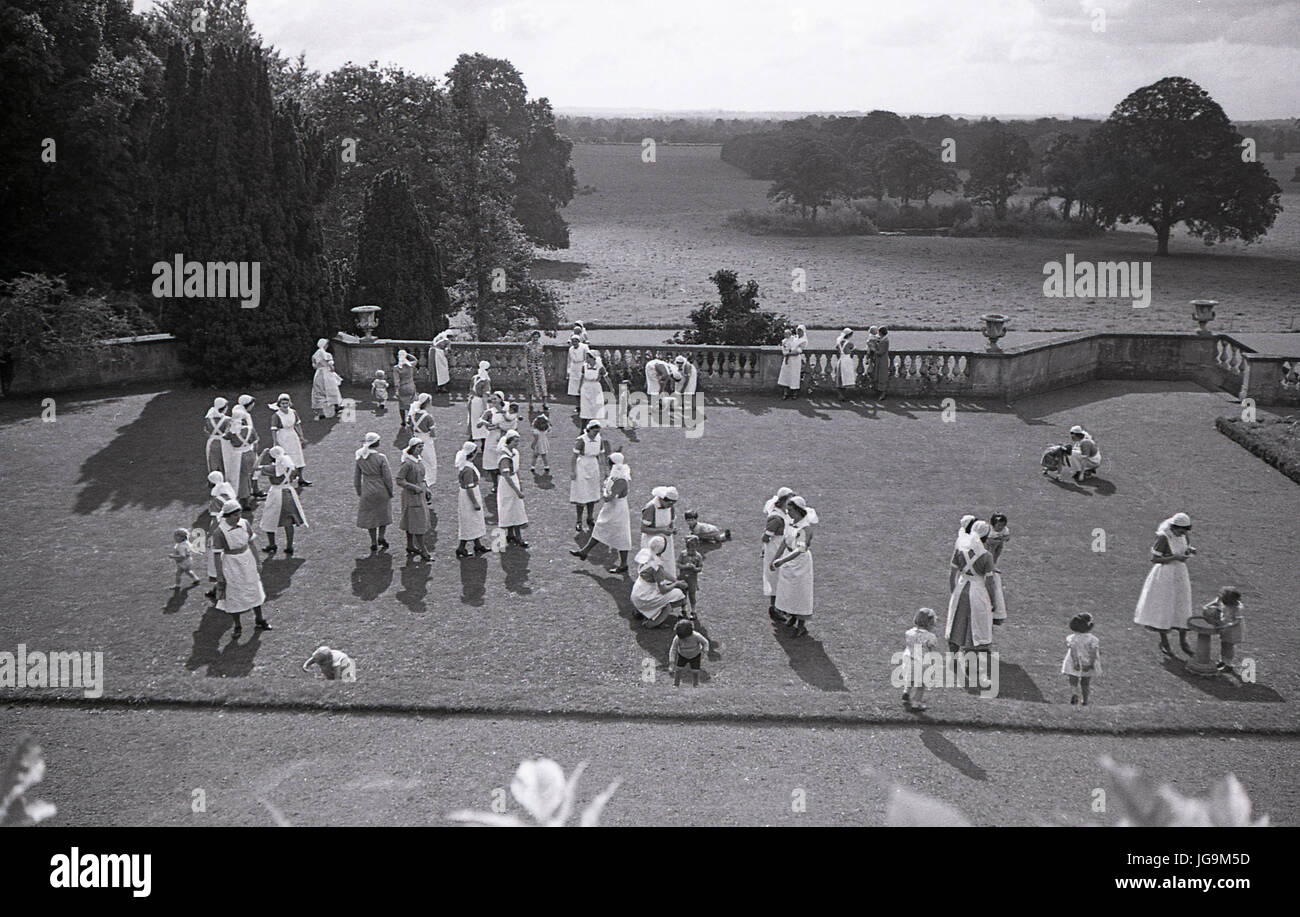 1940, in Inghilterra, in tempo di guerra, gli infermieri con i bambini nel parco di Stanstead Hall, casa di lady Butler (Sydney Courtauld) moglie del maggiordomo di Rab, politico conservatore, gli infermieri erano lì a guardare dopo che il bambino di sfollati da Londra che avevano lasciato durante il blitz. Foto Stock