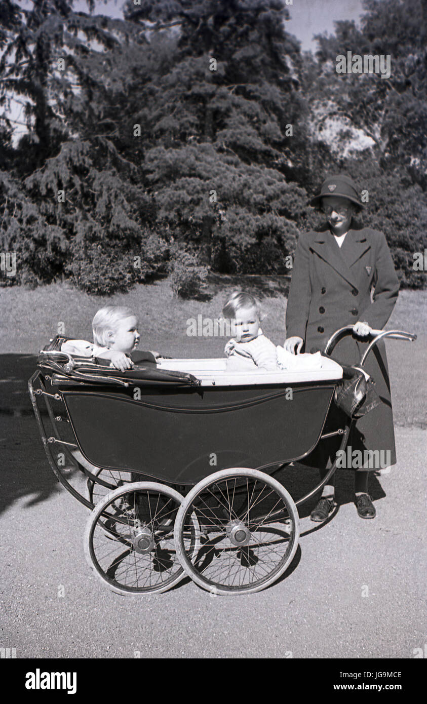 1940, in Inghilterra, in tempo di guerra di sfollati, nanny con piccoli bambini seduti fuori in un cromato con ruote costruito in pullman la PRAM, nella motivazione di Stanstead Hall, la casa di Sydney Courtauld, Lady Butler, moglie del maggiordomo di Rab, politican conservatore. Foto Stock