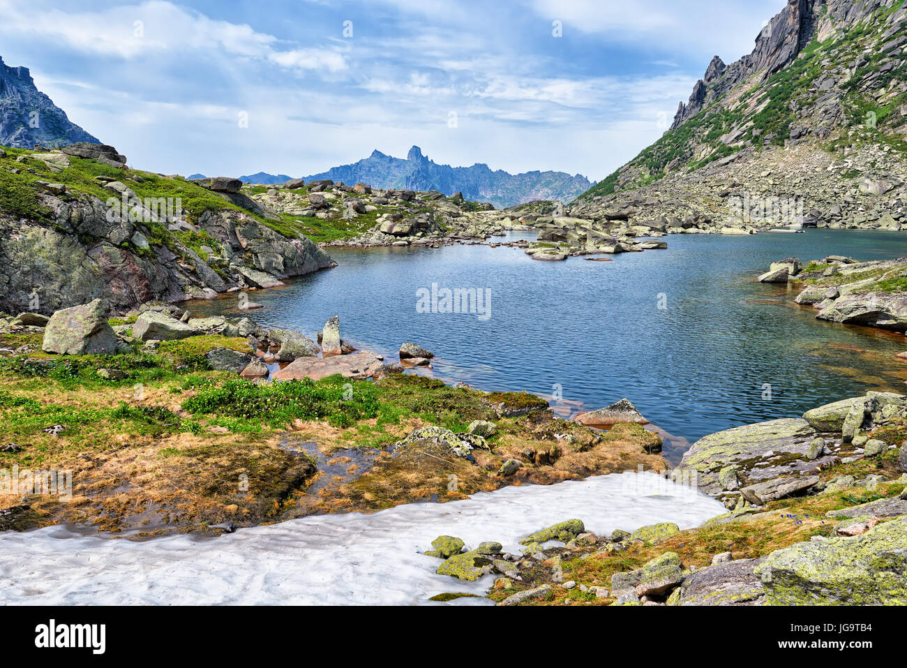 Lago di montagna nella valle del pensile e fusione di neve. Ergaki Ridge. Western Sayan. Siberia Meridionale. La Russia Foto Stock