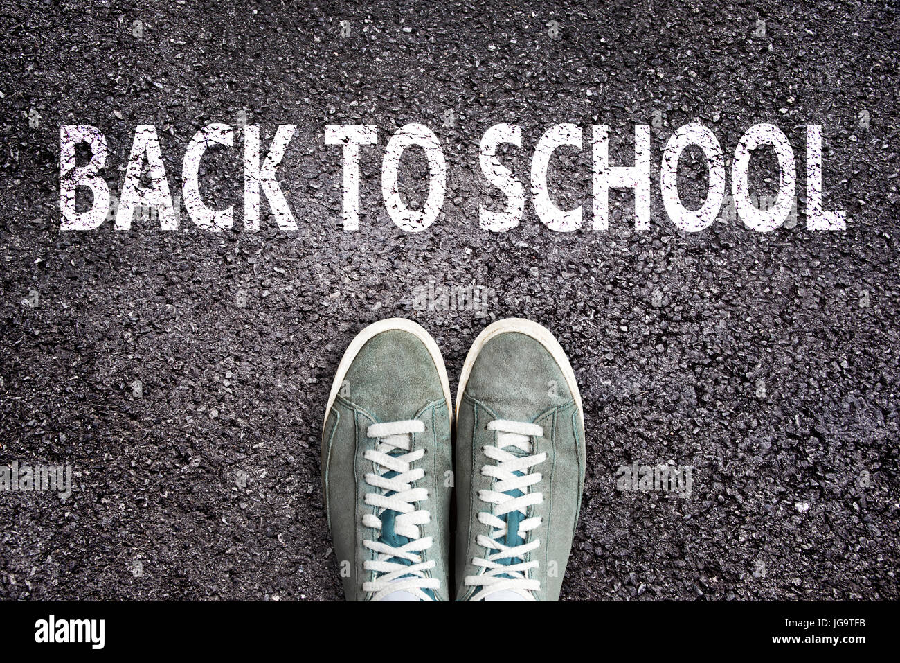 Parole torna a scuola scritto su strada asfaltata con scarpe da ginnastica, high school e college di concetto Foto Stock