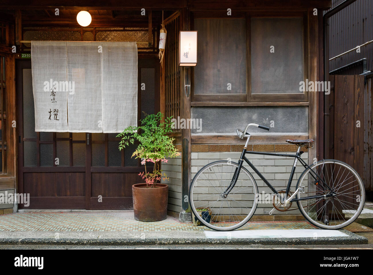 Il vecchio parcheggio bici su un sentiero nella parte anteriore della casa in da strada in una città del Giappone Foto Stock