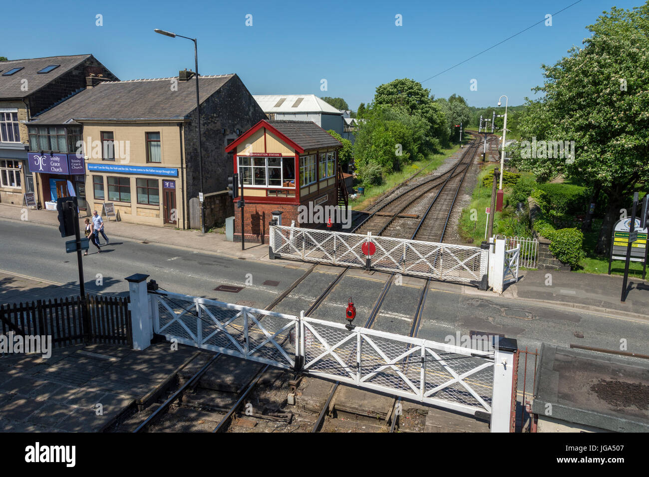 La casella segnale e il passaggio a livello (gates impostata per lo spostamento su strada), sulla East Lancashire Railway a Ramsbottom, Greater Manchester, Regno Unito. Foto Stock