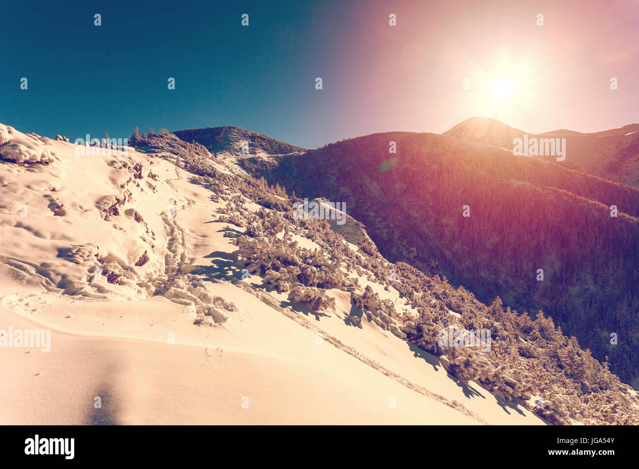 Paesaggio invernale con regolazione del sole Foto Stock
