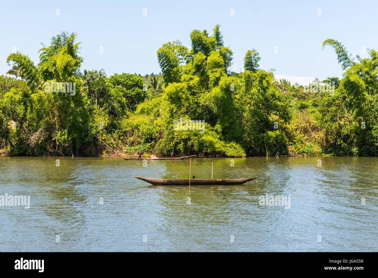 Ivoloina, Madagascar - Dicembre 22, 2015: campagna malgascio persone dal villaggio di trasporto da tradizionale a mano piroga imbarcazione in legno vicino a t Foto Stock