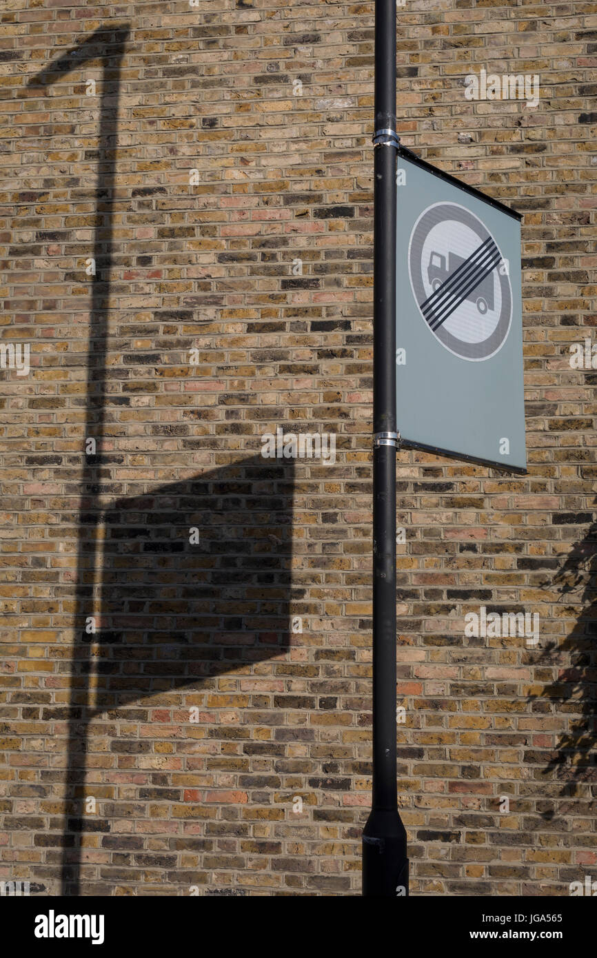 L ombra di una vicina lampada posta piazza e segno di traffico sul muro di mattoni di un fine casa a schiera, in data 3 luglio 2017, a Herne Hill, Londra, Inghilterra. Foto Stock