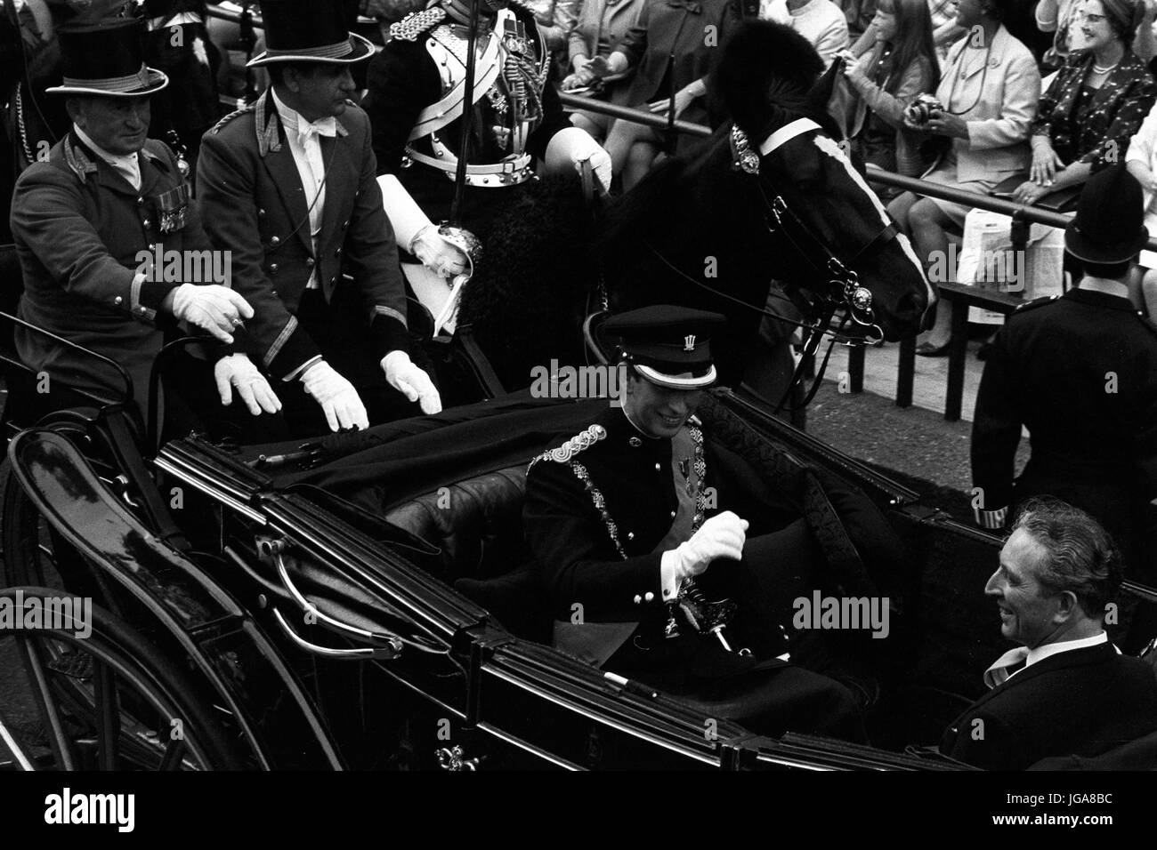 Il Sorridente Principe di Galles, in uniforme come colonnello in capo del reggimento reale del Galles, riconosce le acclamazioni della folla come egli è guidato in un carrello aperto a Caernarvon Castle Gate d'acqua. Con lui è George Thomas, il Segretario di Stato per il Galles. Foto Stock
