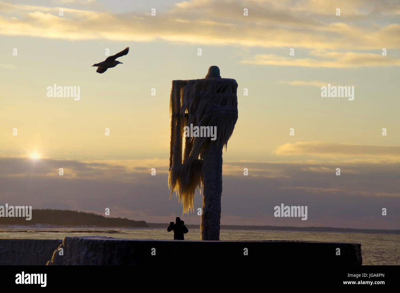 Una skyline di ghiaccioli sul porto congelata la lampada sul molo. inverno dal mare. Foto Stock
