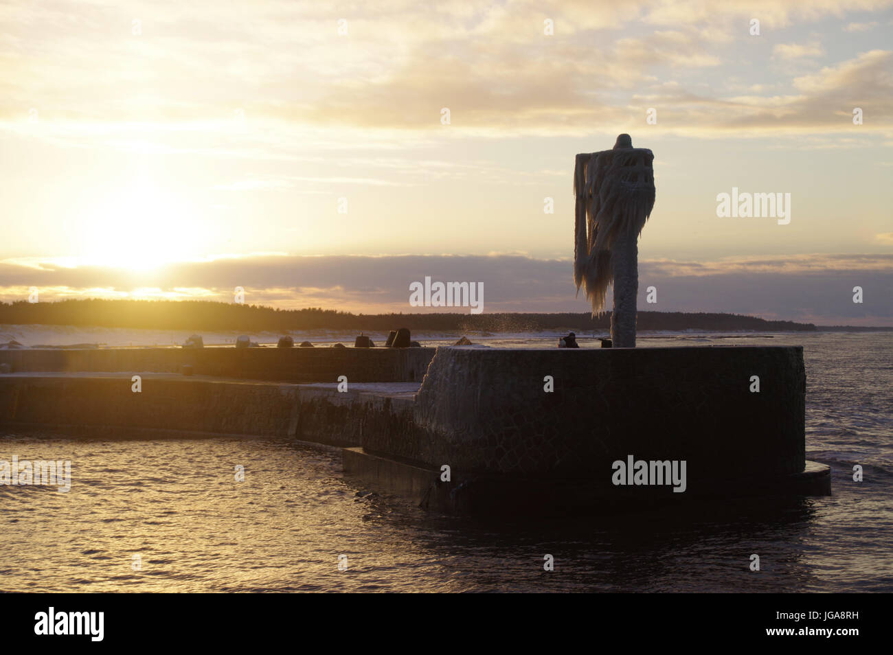 Una skyline di ghiaccioli sul porto congelata la lampada sul molo. Inverno dal mare. Foto Stock