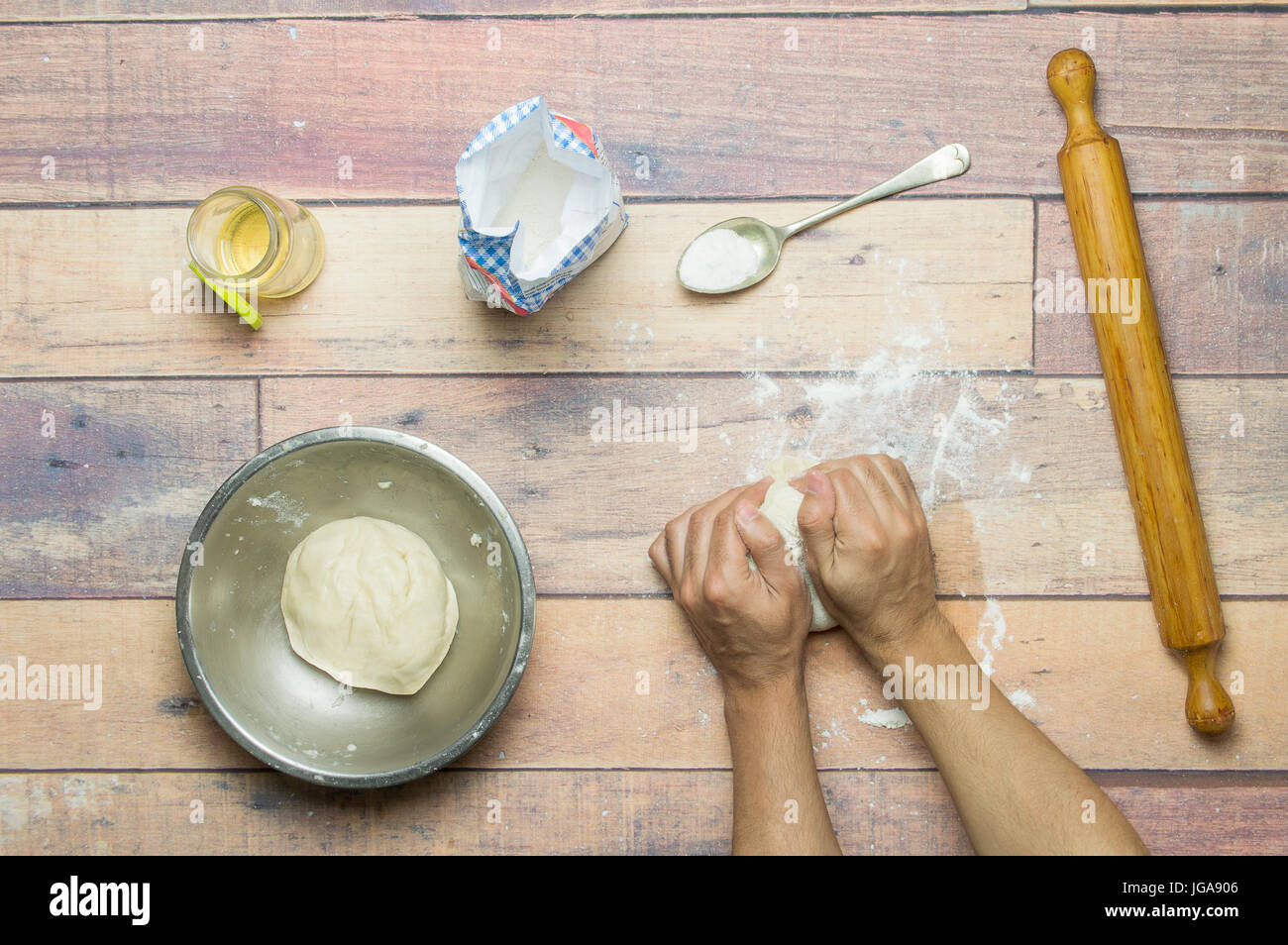 impastare la pasta per cuocere la torta su un tavolo di legno Foto Stock