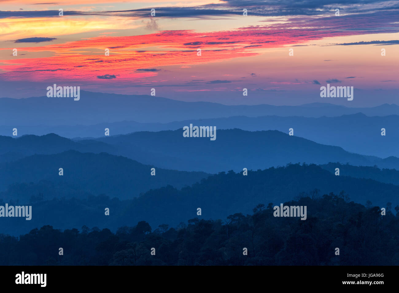 Strato di montagne nella nebbia al tramonto del tempo con la masterizzazione di sky, Nan Provincia, Thailandia Foto Stock