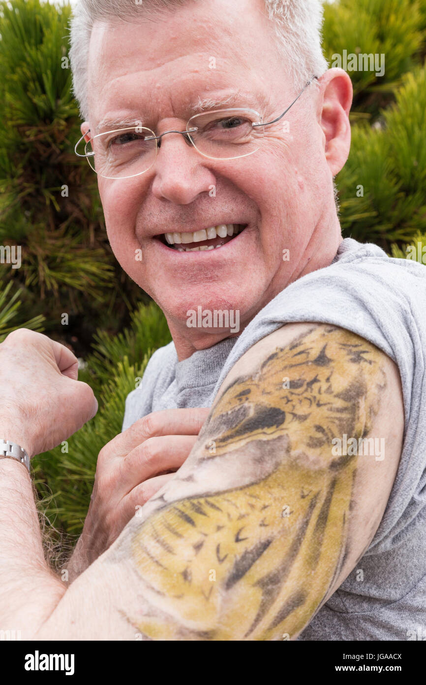 Senior uomo in mostra il suo nuovo di tatuaggi, STATI UNITI D'AMERICA Foto Stock