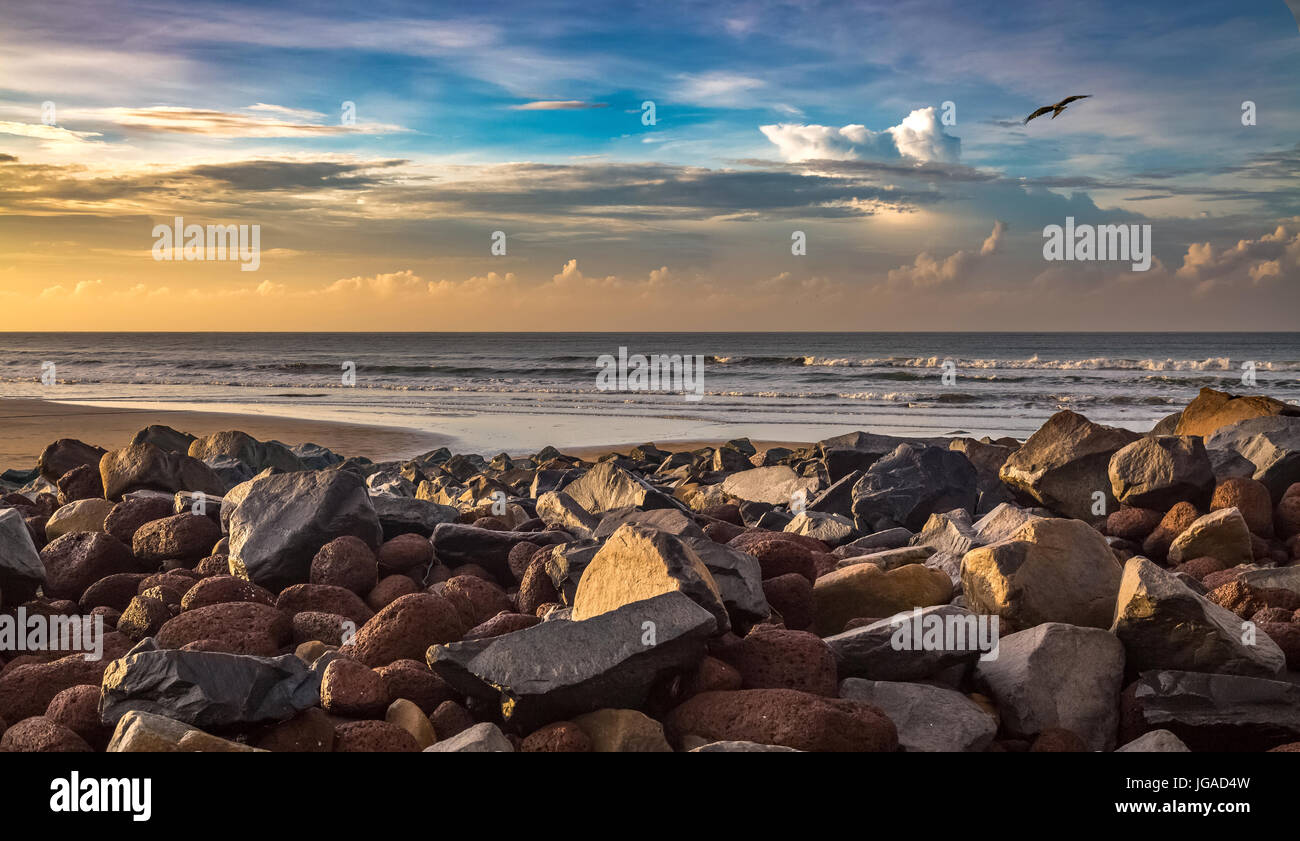 Sunrise in una spiaggia in India con seascape rocce e moody sky Foto Stock