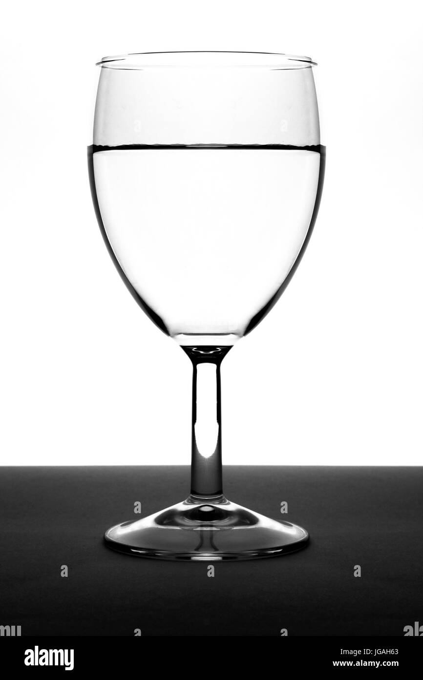 Un bicchiere di acqua che è fotografata in studio. una valutazione un bianco morbido casella con flash. il vetro è stato collocato su una superficie piatta con il grigio scuro Foto Stock