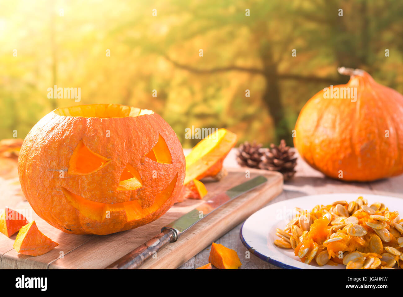 Il carving un Jack O'Lanterna su un rustico tavolo esterno in autunno. Foto Stock