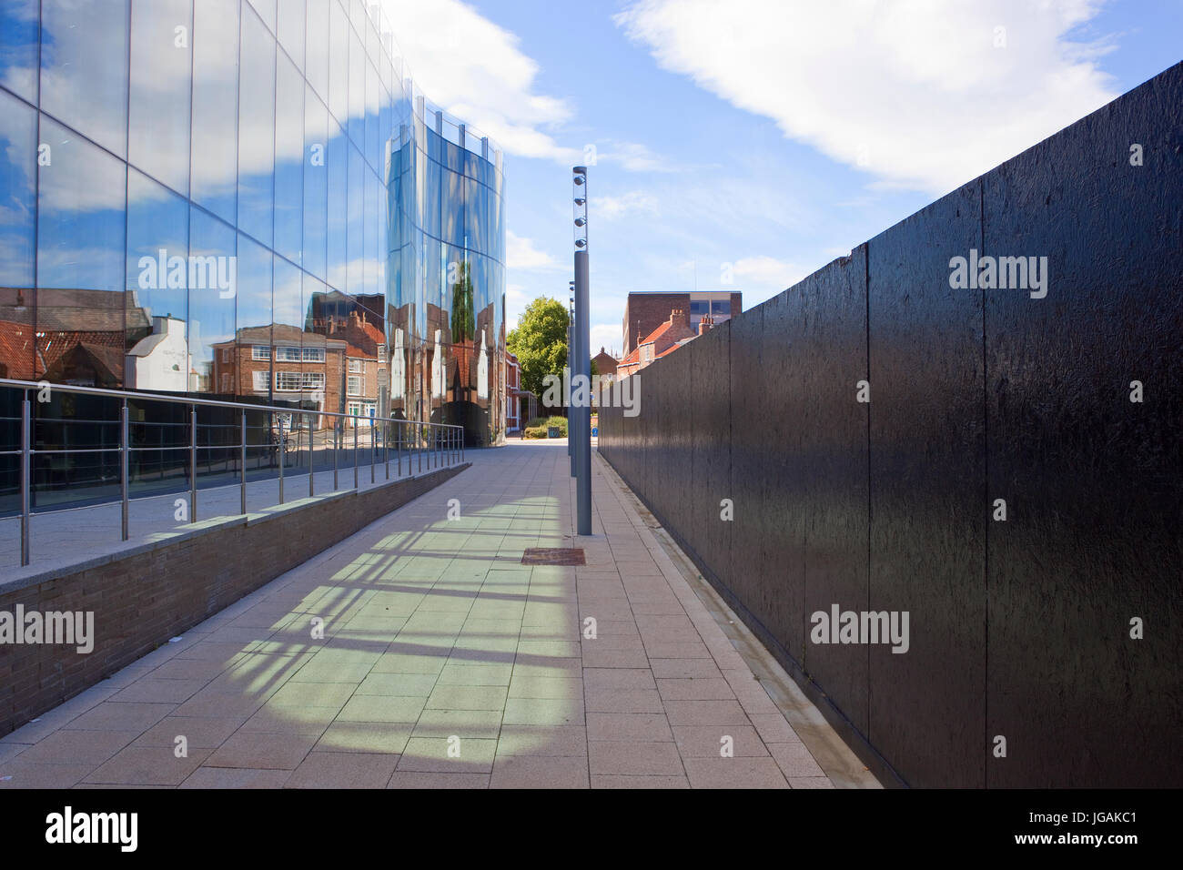 Edifici storici e l'estate cielo riflessa nei lati di vetro di un edificio moderno nel centro storico della città di York. Foto Stock