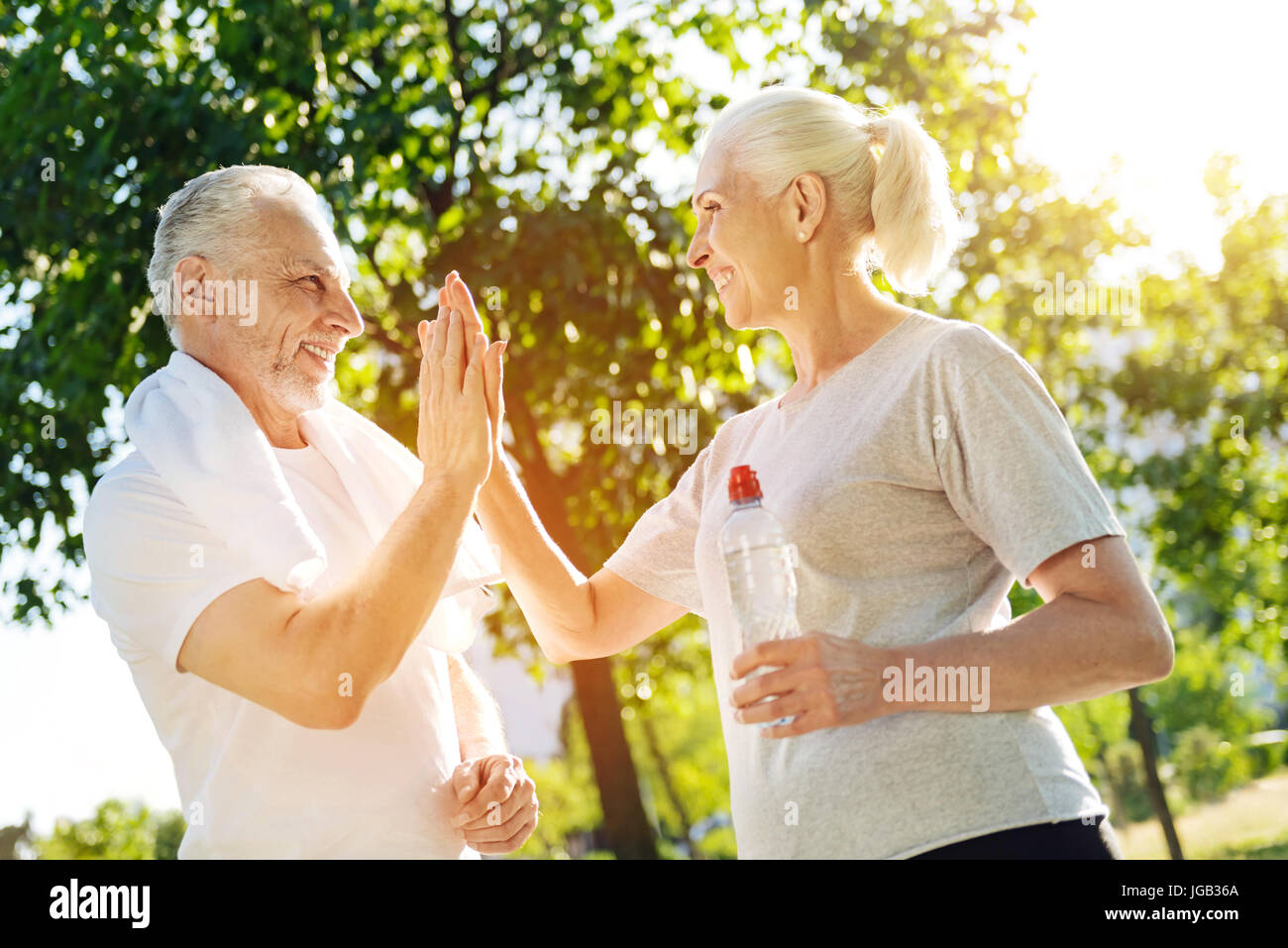 Positivo di età matura in appoggio nel parco dopo il jogging Foto Stock