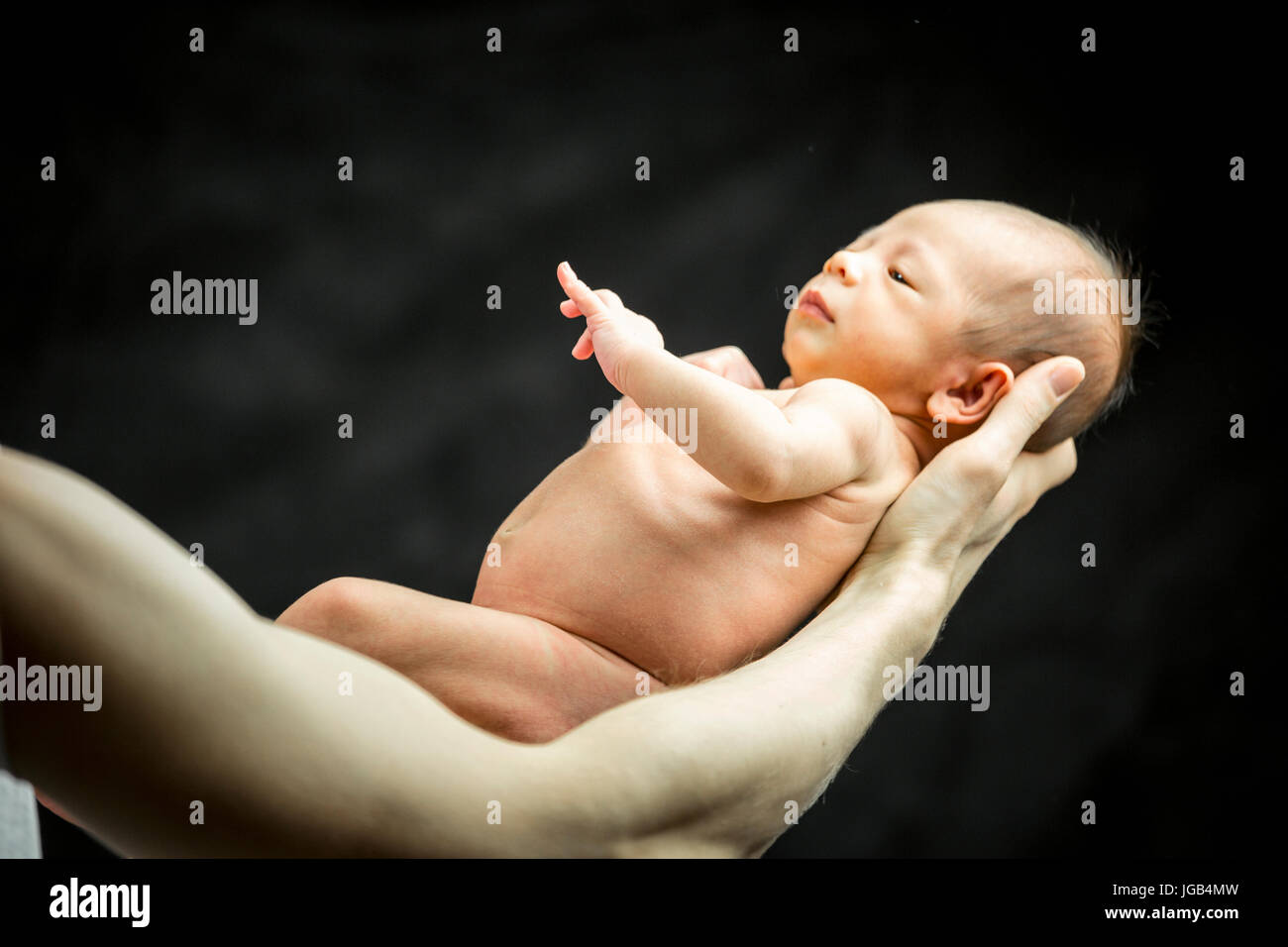 A 3 settimane di età baby figlio recante sulla sua mano del padre Foto Stock