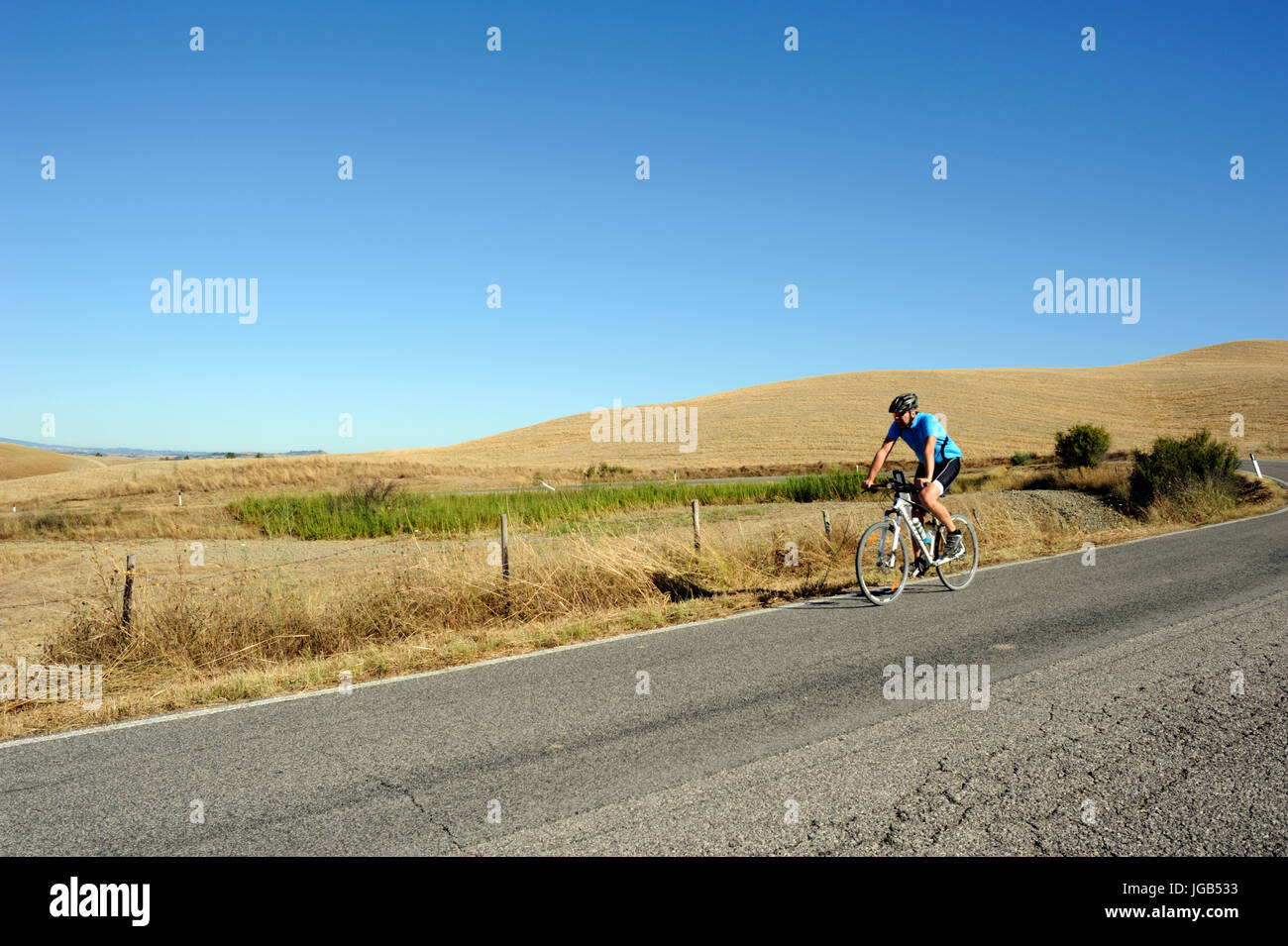 Italia, Toscana, Crete Senesi, strada, ciclista Foto Stock