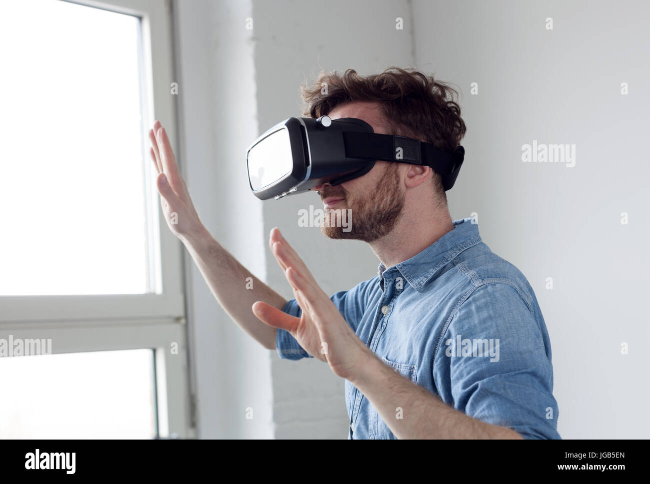 Stupito uomo che indossa occhiali per realtà virtuale Foto Stock