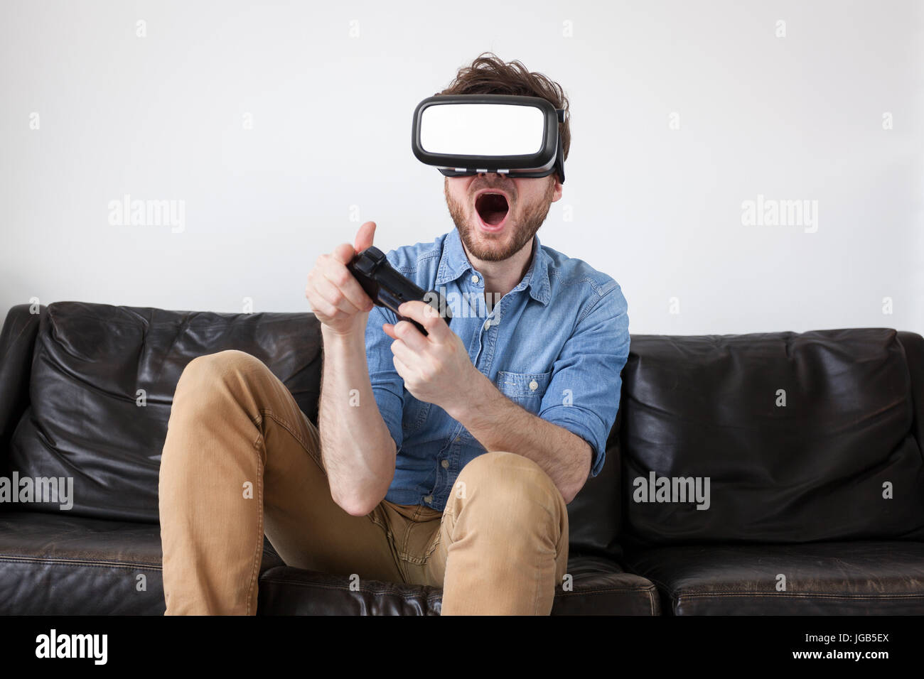 L'uomo su un lettino che indossa la realtà virtuale gli occhiali e la riproduzione di un gioco Foto Stock
