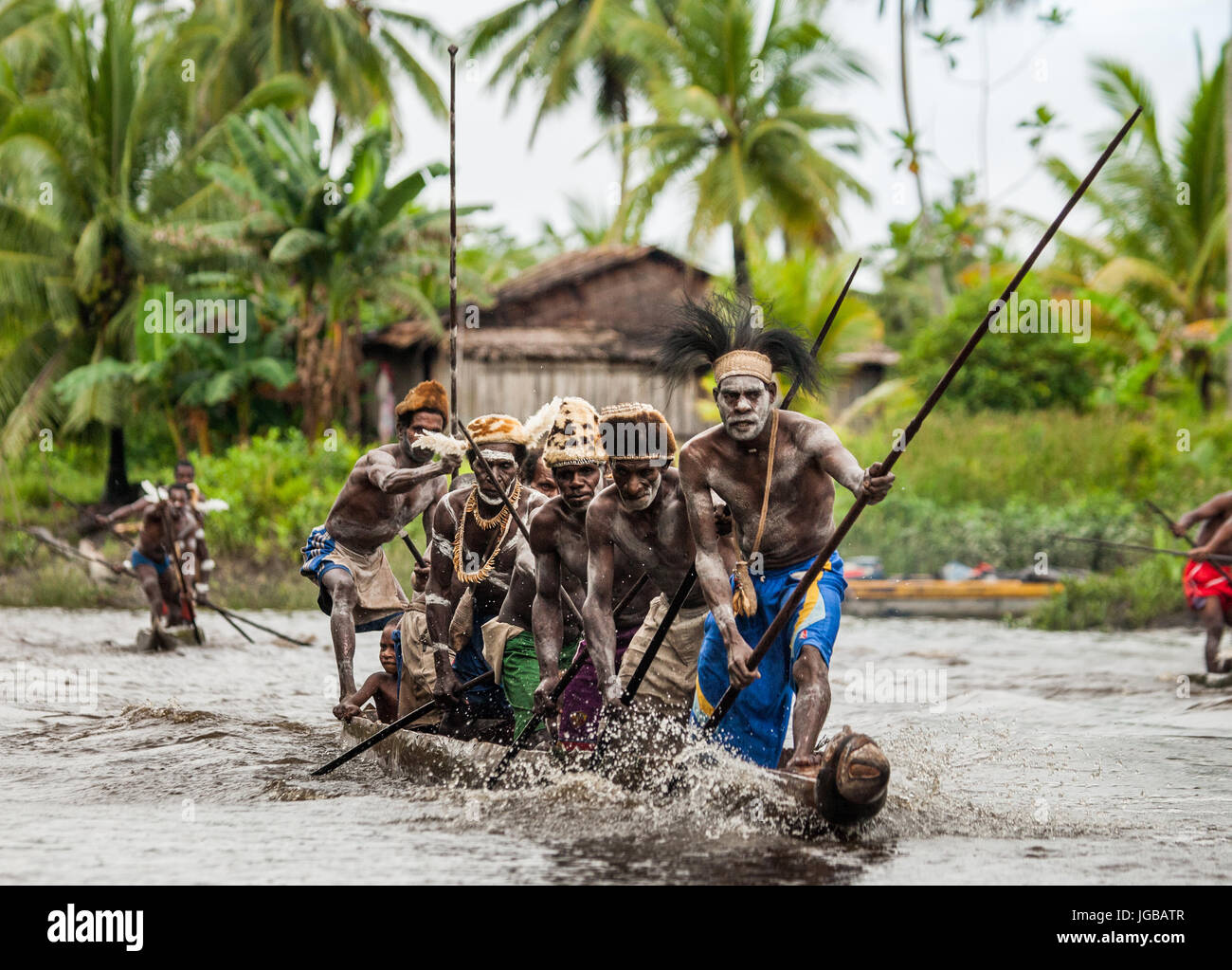 INDONESIA, Irian Jaya, ASMAT provincia, JOW VILLAGE - 12 giugno: Warriors Asmat tribù sono uso canoe tradizionali. Foto Stock