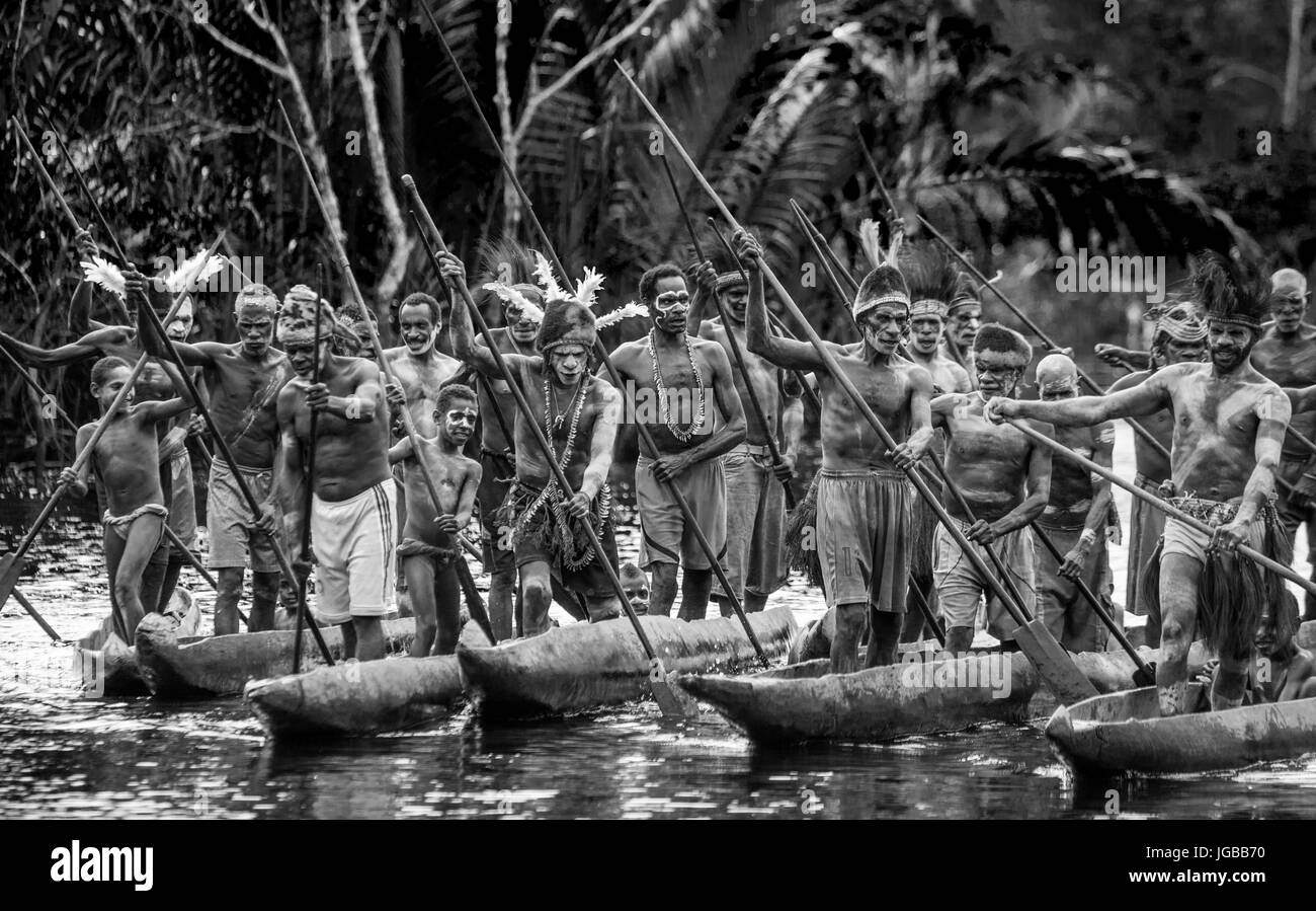 INDONESIA, Irian Jaya, ASMAT provincia, JOW VILLAGE - 12 giugno: Warriors Asmat tribù sono uso canoe tradizionali. Foto Stock