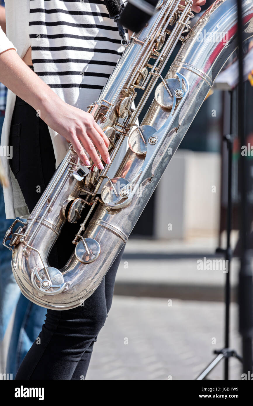 Giovane sassofonista effettuando in corrispondenza di strada durante il city music fest Foto Stock