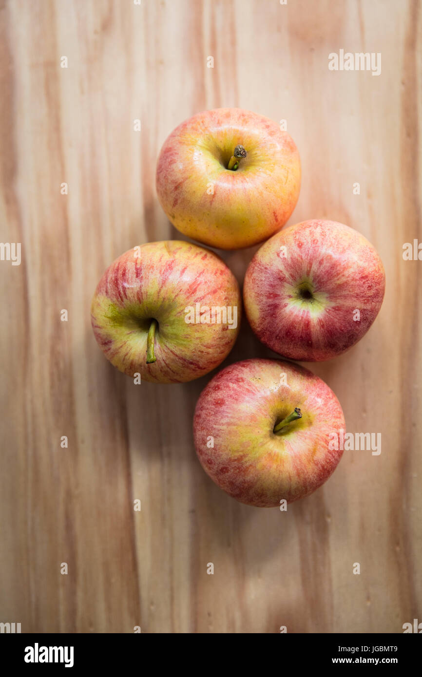 Quattro le mele su una superficie di legno. Pink Lady varietà Foto Stock