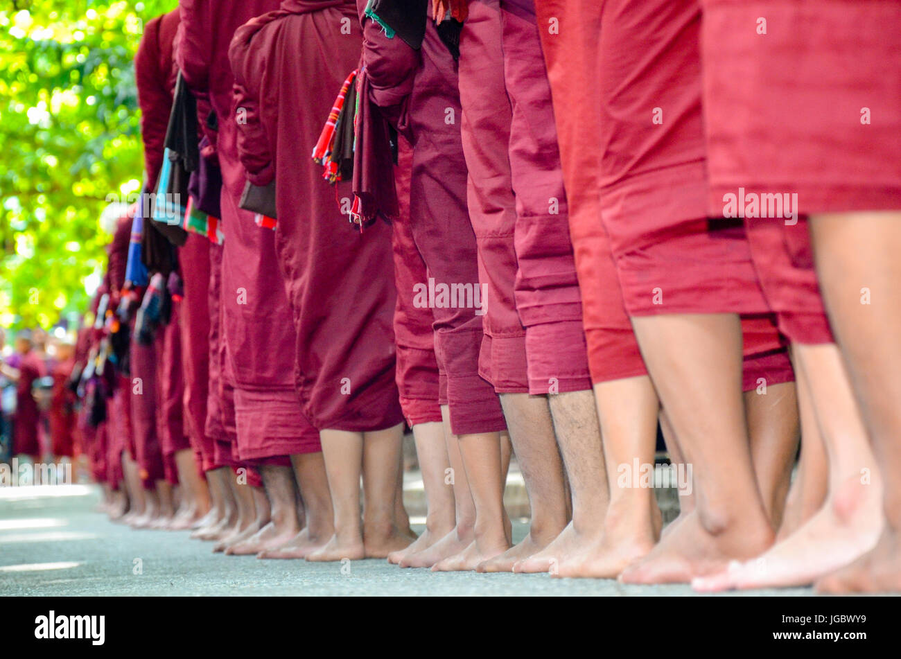 I monaci buddisti raccogliendo elemosine al tempio di Mandalay, Myanmar Foto Stock