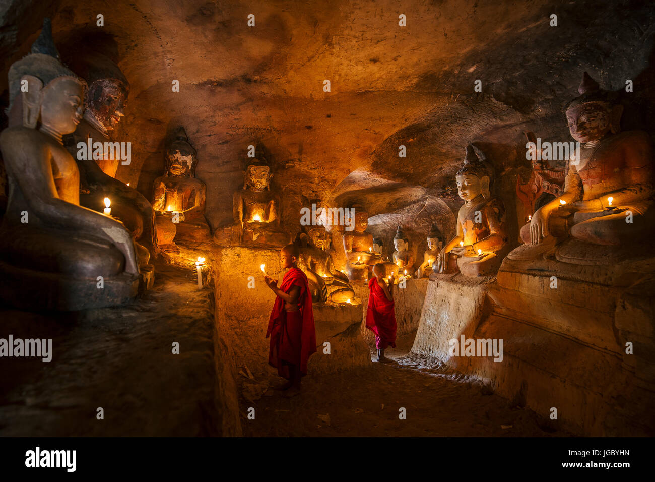 Buddista monaco novizio pregando all'interno di Po Win Taung in una caverna nel Nord del Myanmar - Sagaing regione - Monywa - Myanmar Foto Stock
