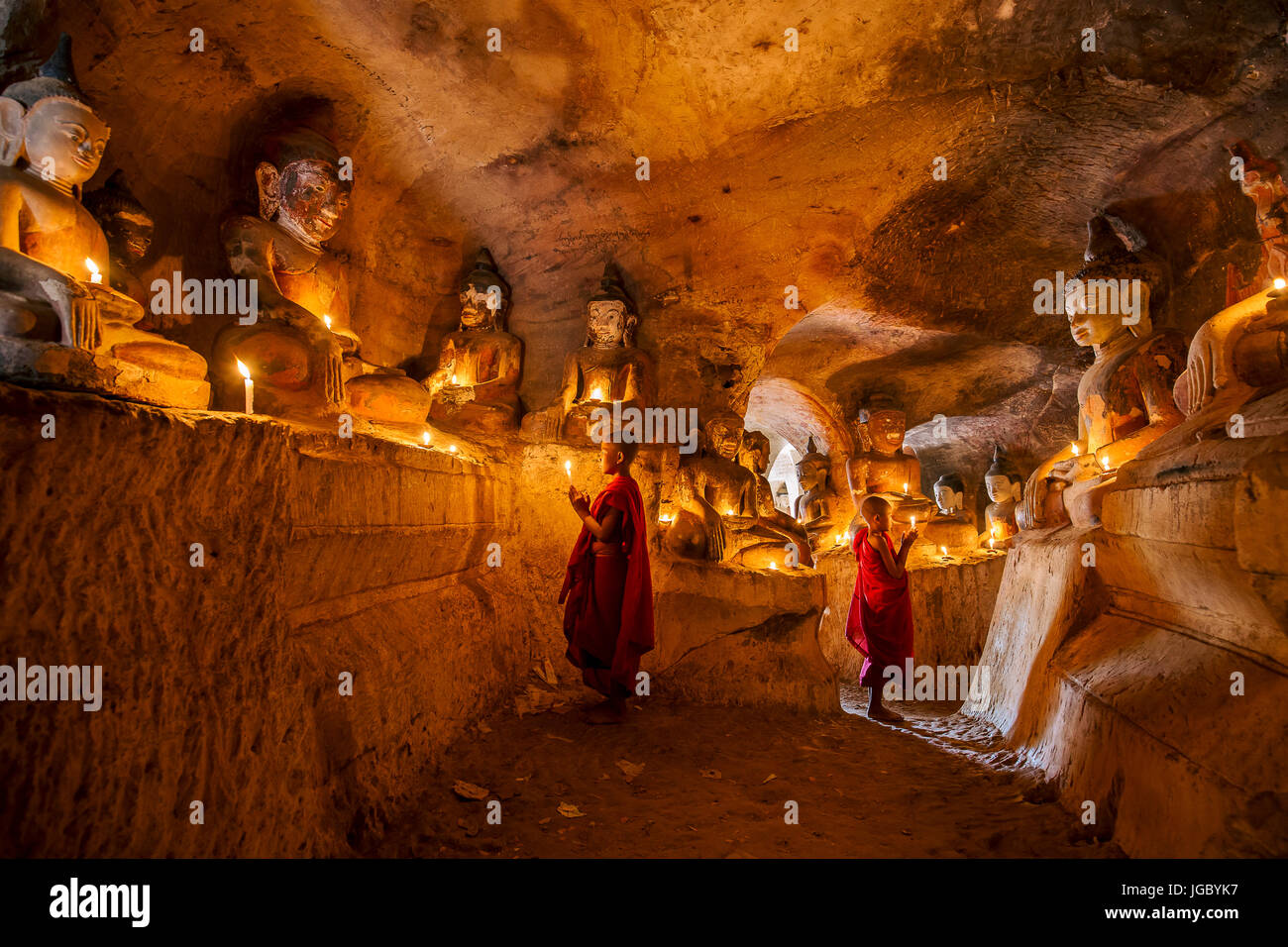 Buddista monaco novizio pregando all'interno di Po Win Taung in una caverna nel Nord del Myanmar - Sagaing regione - Monywa - Myanmar Foto Stock