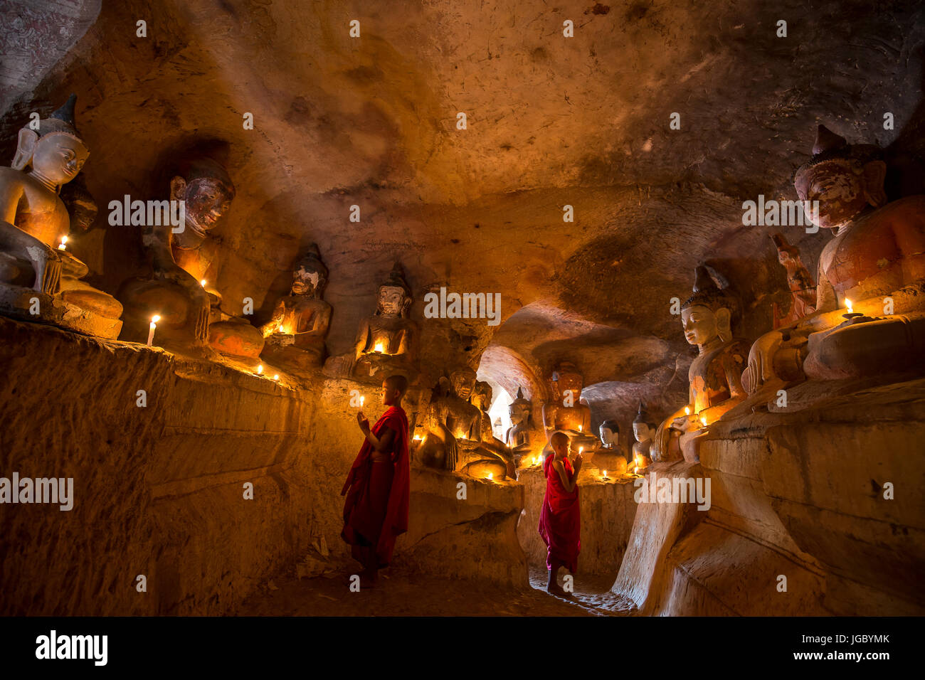 Buddista monaco novizio pregando all'interno di Po Win Taung in una caverna nel Nord del Myanmar - Sagaing regione - Monywa - Myanmar Foto Stock