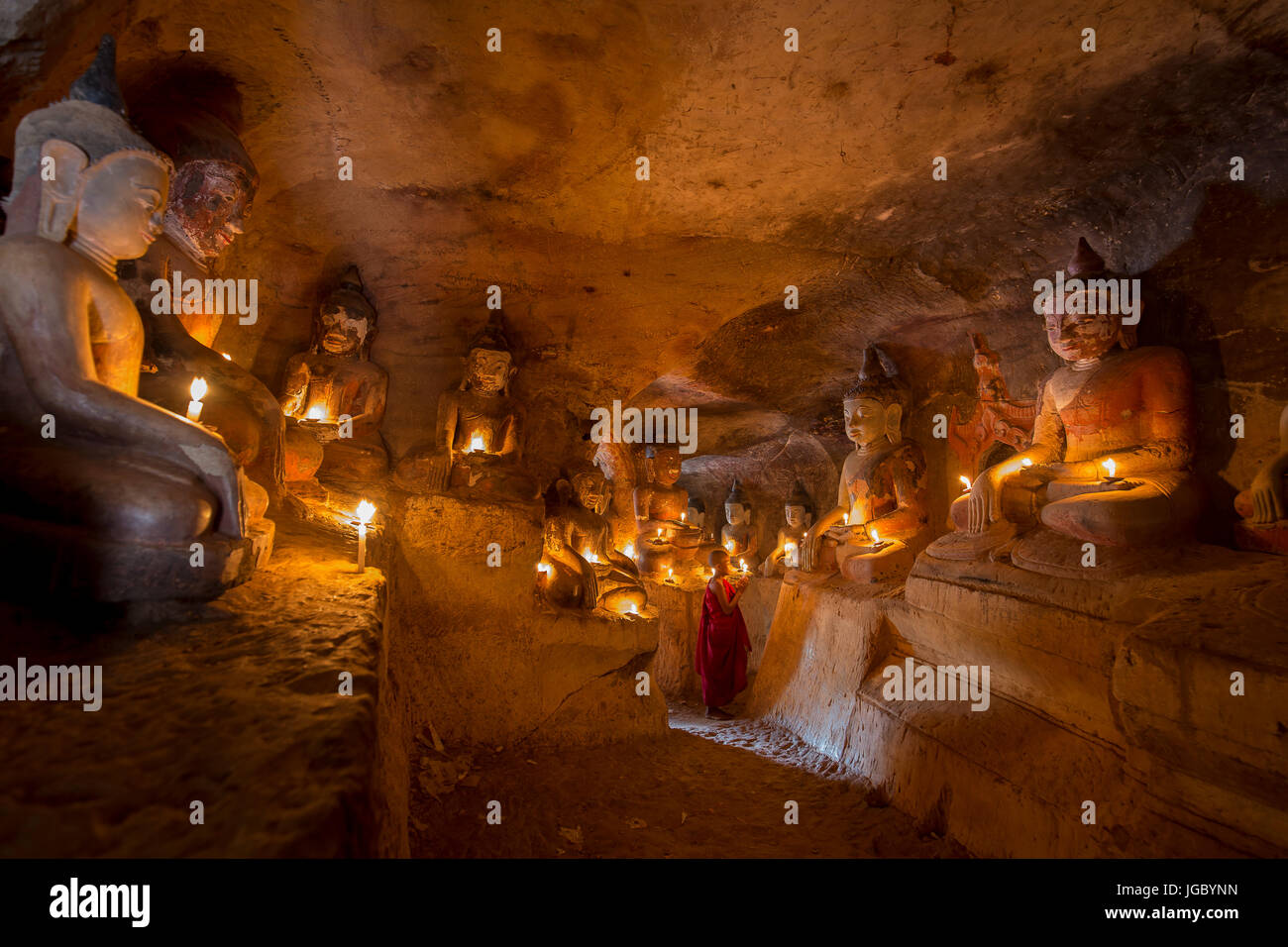 Buddista monaco novizio pregando all'interno di Po Win Taung in una caverna nel Nord del Myanmar - Sagaing regione - Monywa - Myanmar Foto Stock
