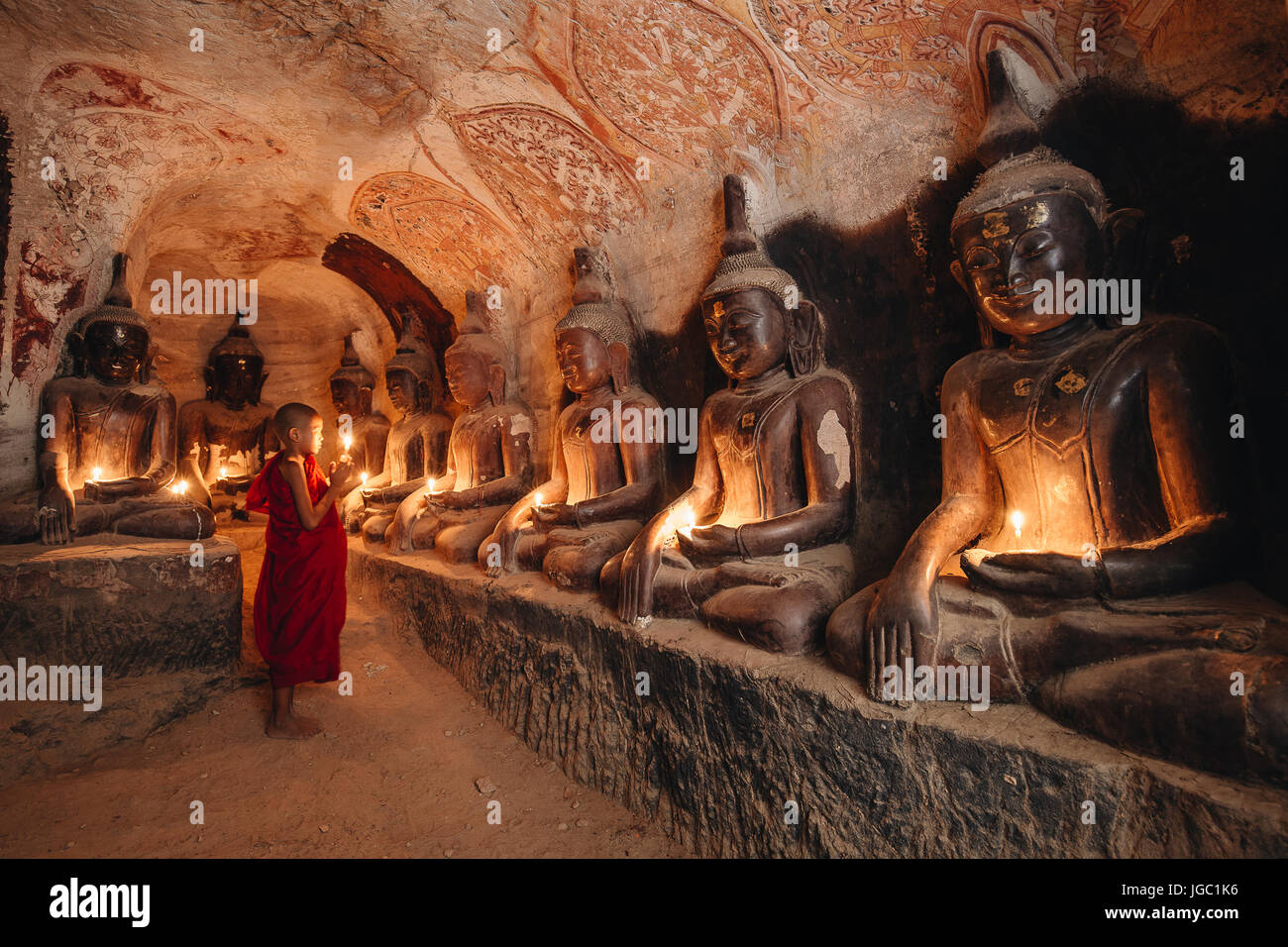Monaco pregando con la luce di una candela in corrispondenza di Po Win Taung / grotta Hpowindaung - Monywa - Sagaing - Regione Nord del Myanmar Foto Stock