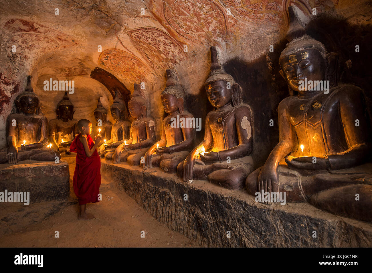 Monaco pregando con la luce di una candela in corrispondenza di Po Win Taung / grotta Hpowindaung - Monywa - Sagaing - Regione Nord del Myanmar Foto Stock
