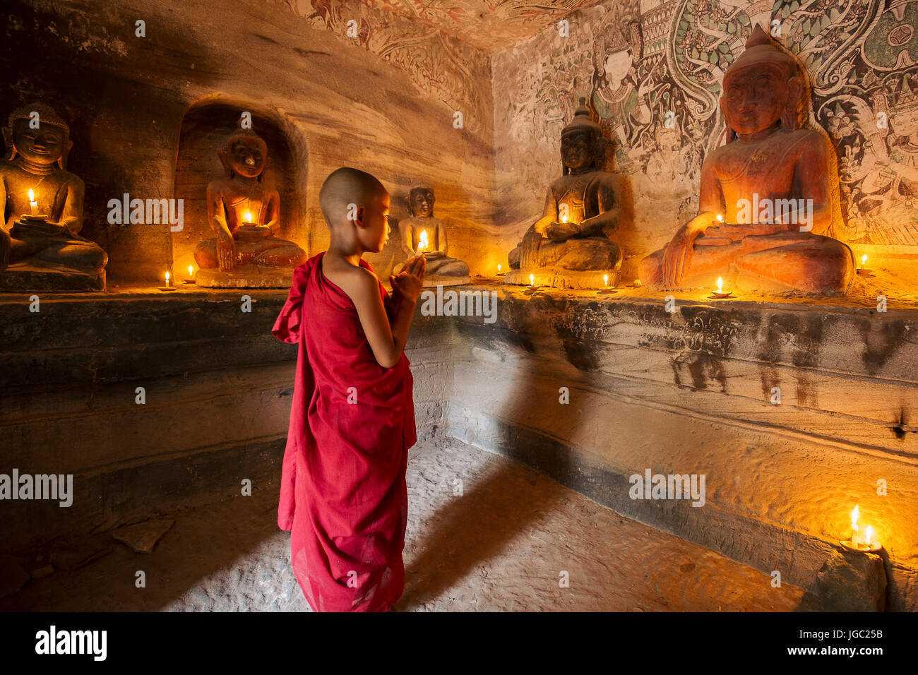 Monaco pregando con la luce di una candela in corrispondenza di Po Win Taung / grotta Hpowindaung - Monywa - Sagaing - Regione Nord del Myanmar Foto Stock