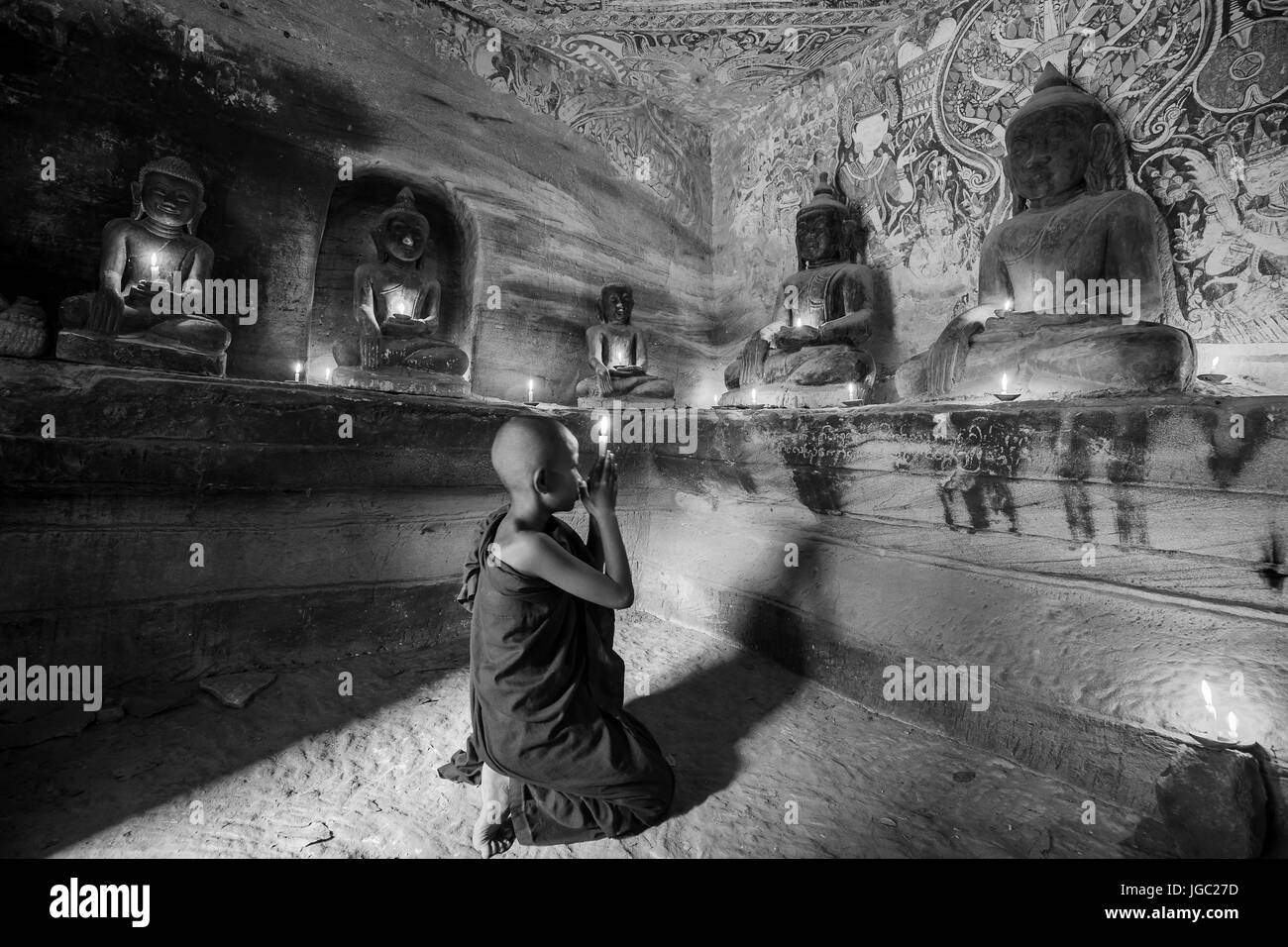 Monaco pregando con la luce di una candela in corrispondenza di Po Win Taung / grotta Hpowindaung - Monywa - Sagaing - Regione Nord del Myanmar Foto Stock